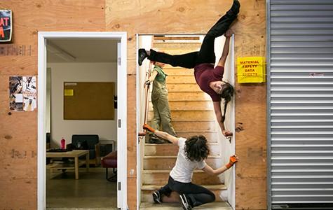 Chris Black, is at the base of the stairs on her knees looking upward towards Megan Lowe whom is suspended upside down in the door frame of the stairwell. Sonsheree is in the background on the stairs peering down at both Chris and Megan. Photo by Bert Johnson. Chris Black, is at the base of the stairs on her knees looking upward towards Megan Lowe whom is suspended upside down in the door frame of the stairwell. Sonsheree is in the background on the stairs peering down at both Chris and Megan.